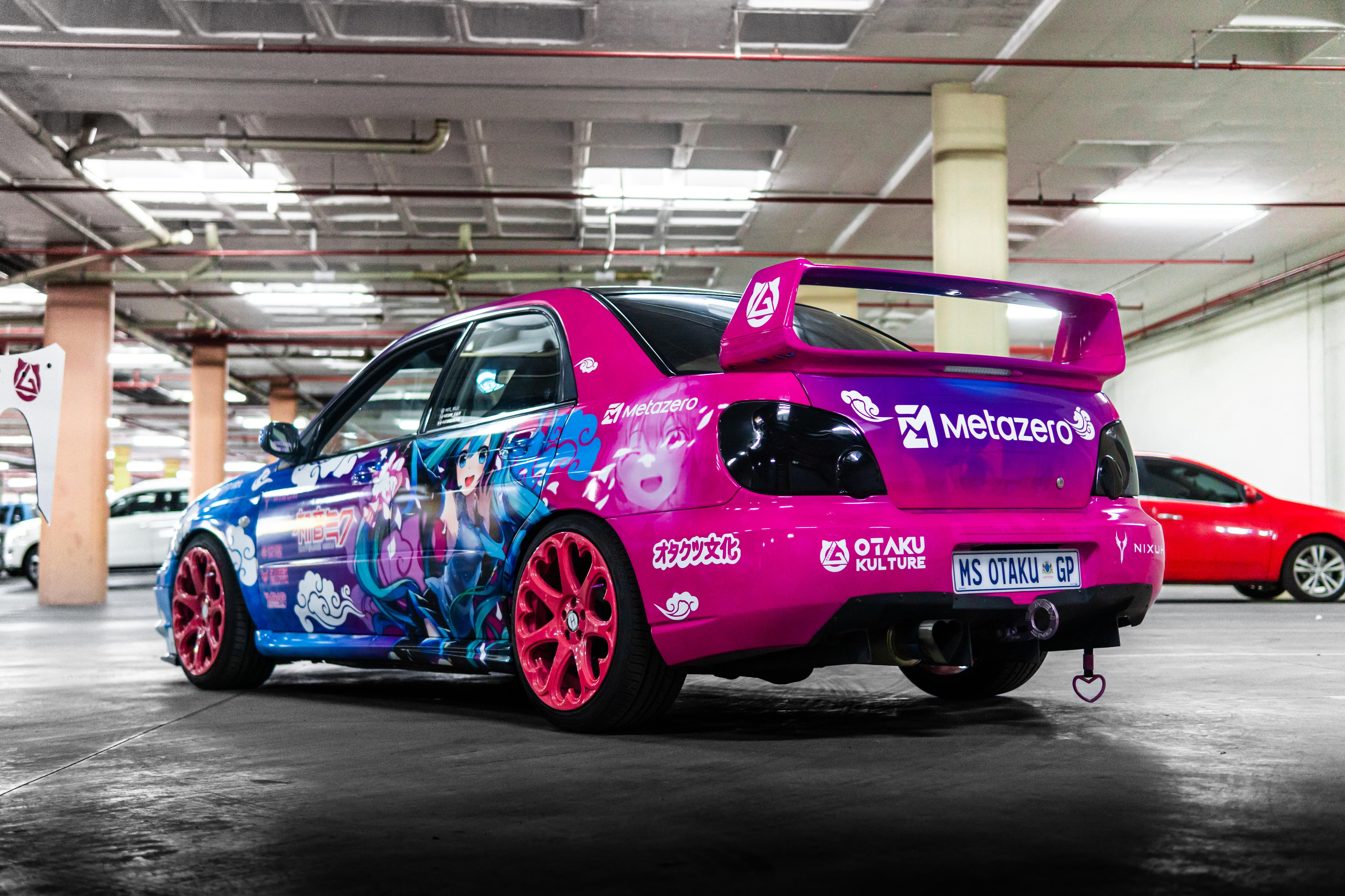 Colorful car with anime-themed wrap in a parking garage